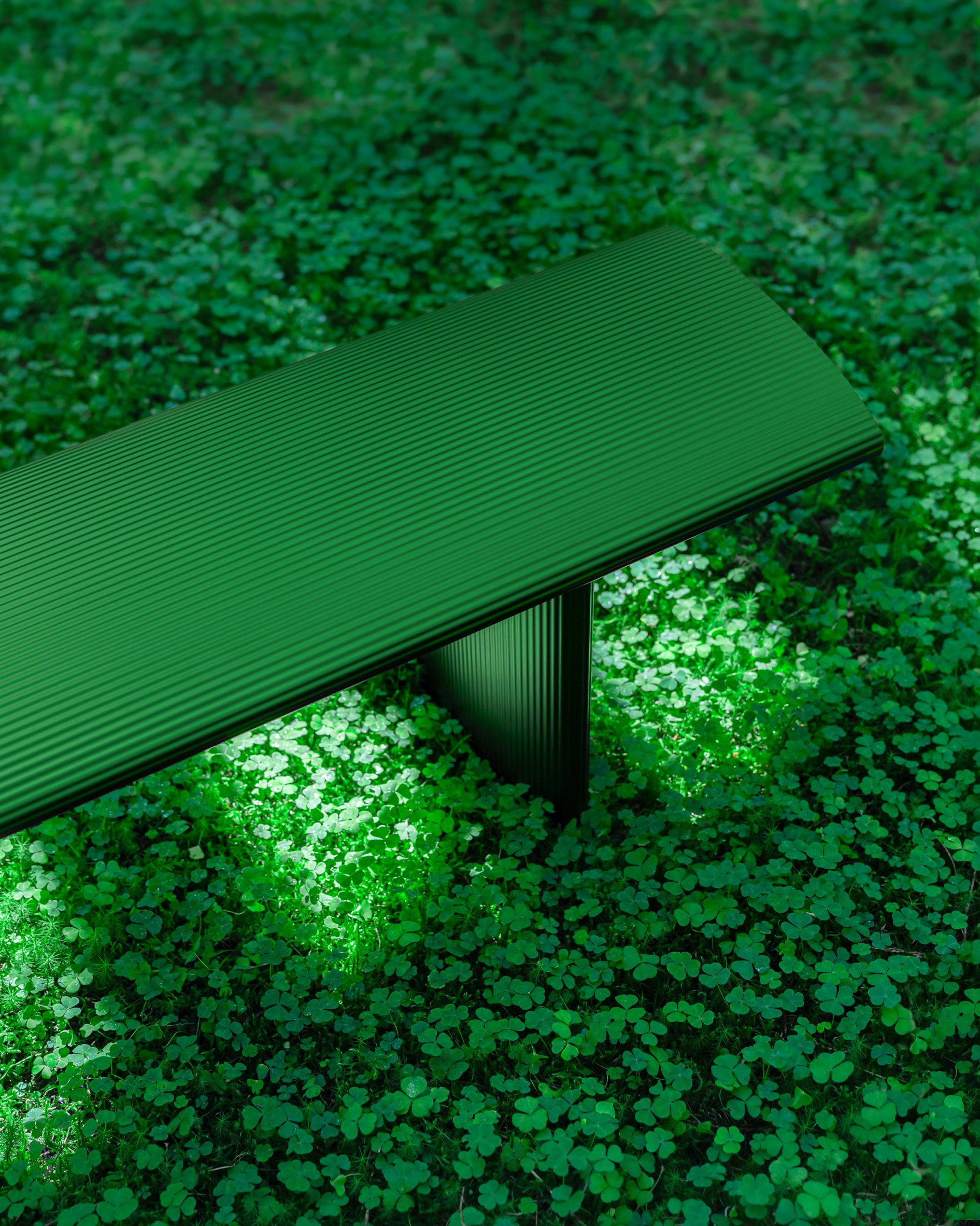 Photo of a green Bello! bench by Hydro and Lars Beller Fjetland camouflaged within a dense field of clover