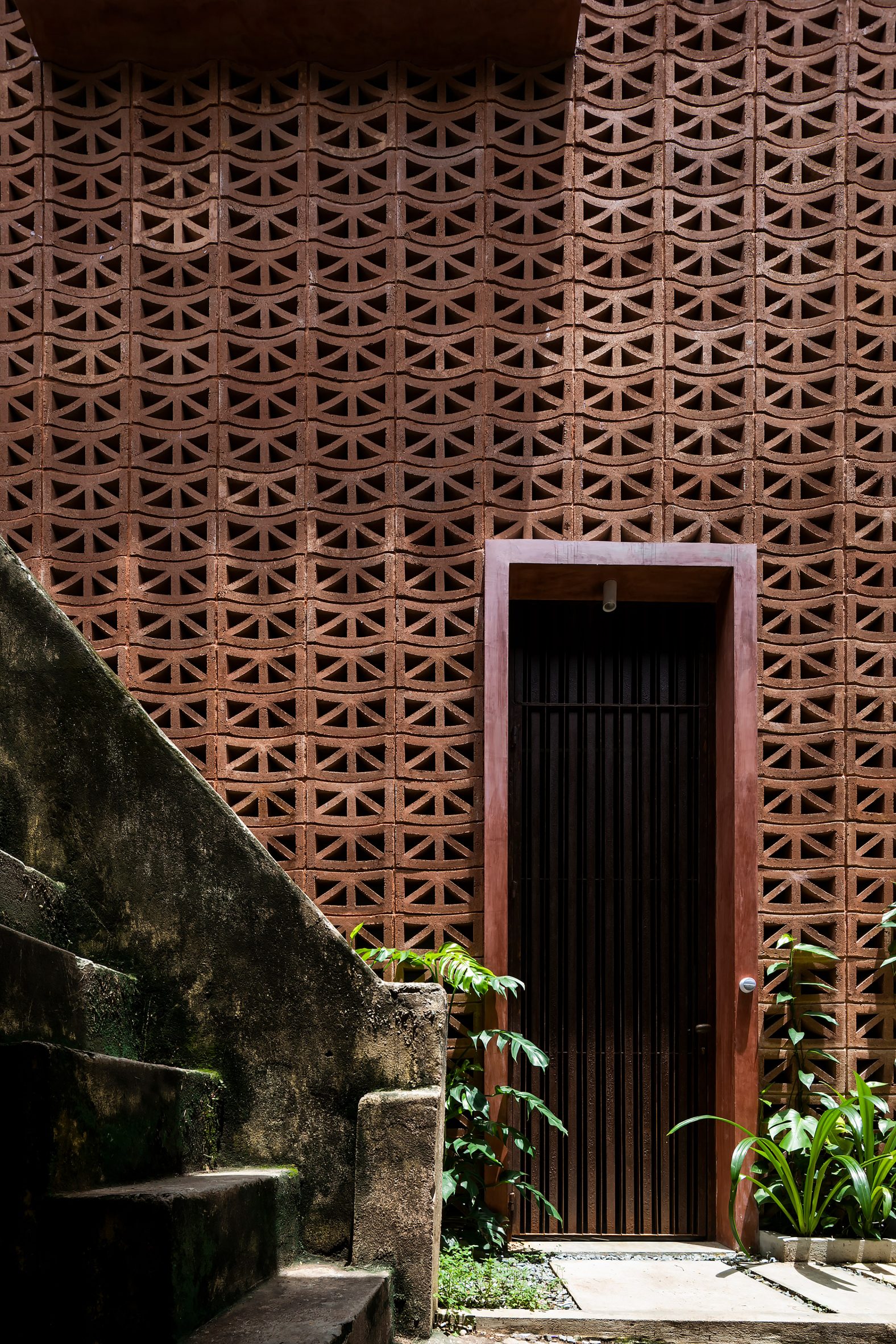 Doorway in a perforated cement block house by Bloom Architecture