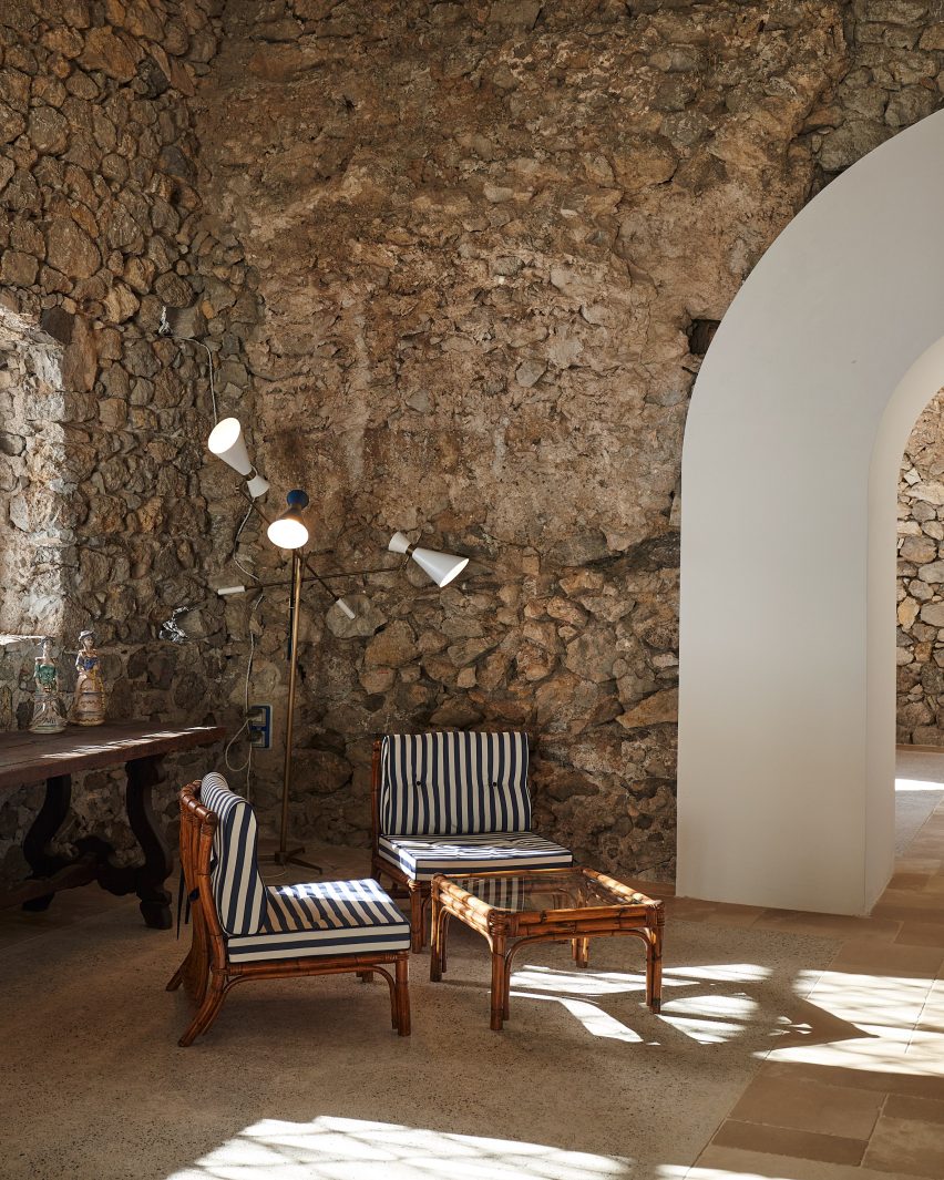 Старая каменная комната со стульями и лампой