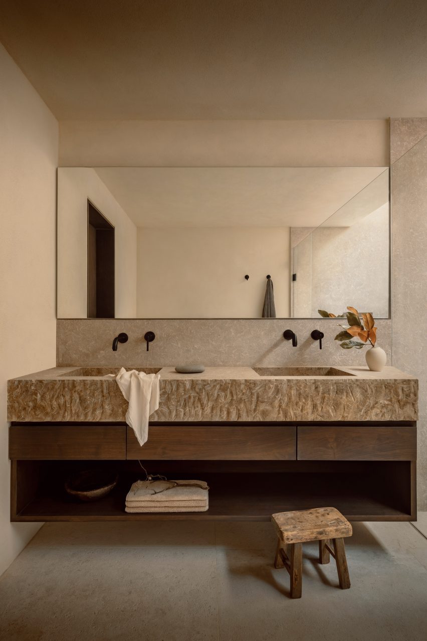 Bathroom vanity with stone sinks and a large mirror above