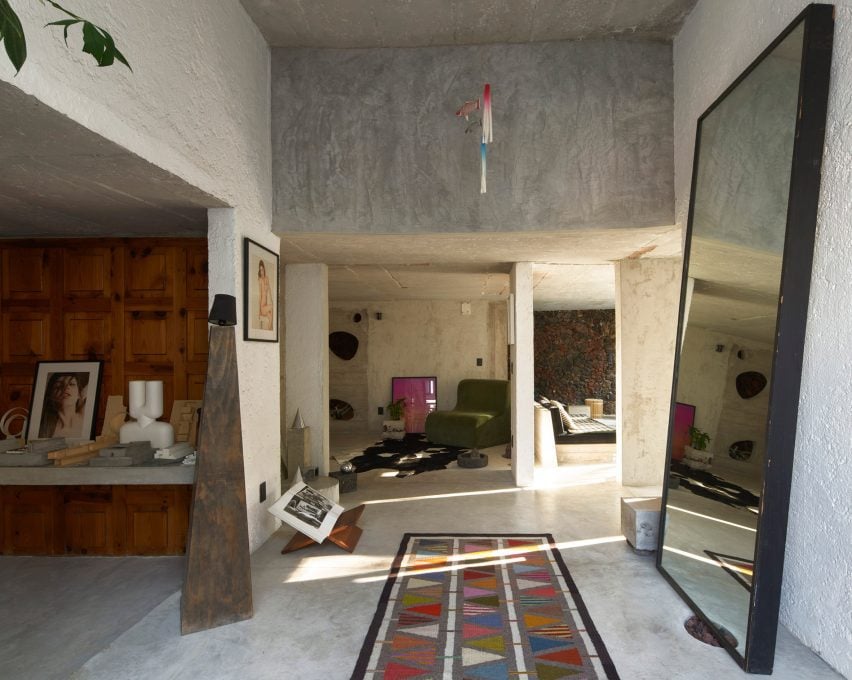 The entrance to a home with a mirror and sculptural elements