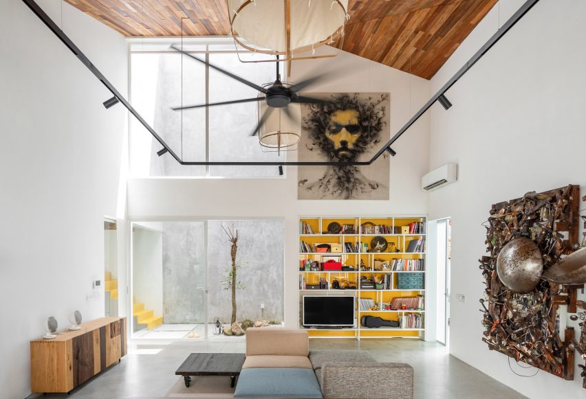 Double-height living room with white walls and timber ceiling
