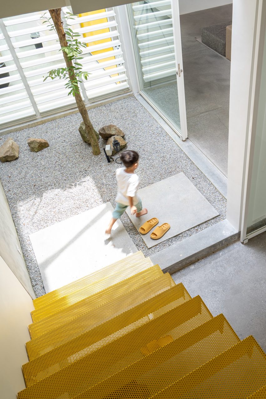 Square courtyard with yellow stairs by Core Design Workshop