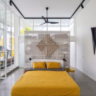 Double-height bedroom with glass doors and yellow bedding