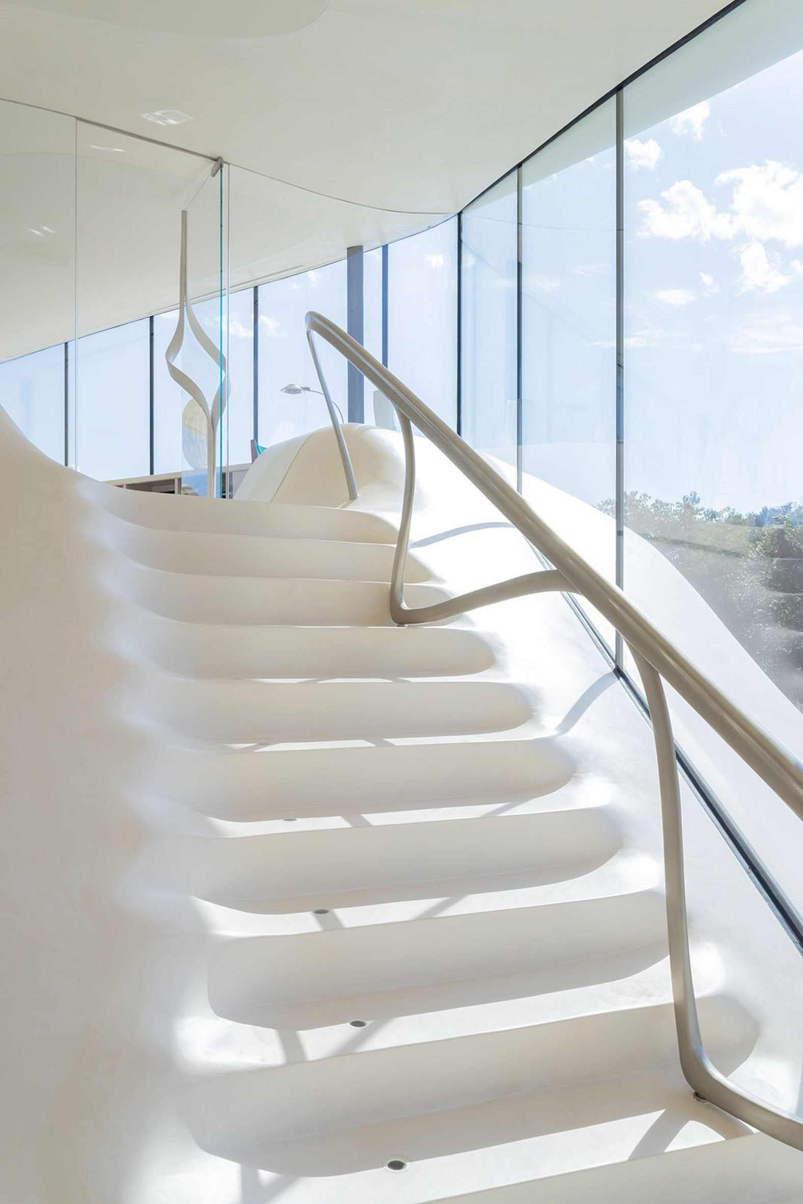 White staircase with sculptural railing