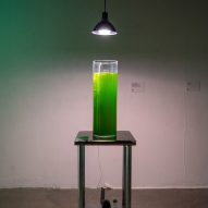 A beaker of bright green liquid underneath a lamp