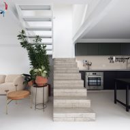 Open-plan living space with concrete staircase