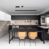 Open-plan kitchen with concrete staircase at Casa Yuji in Sao Paulo by Goiva
