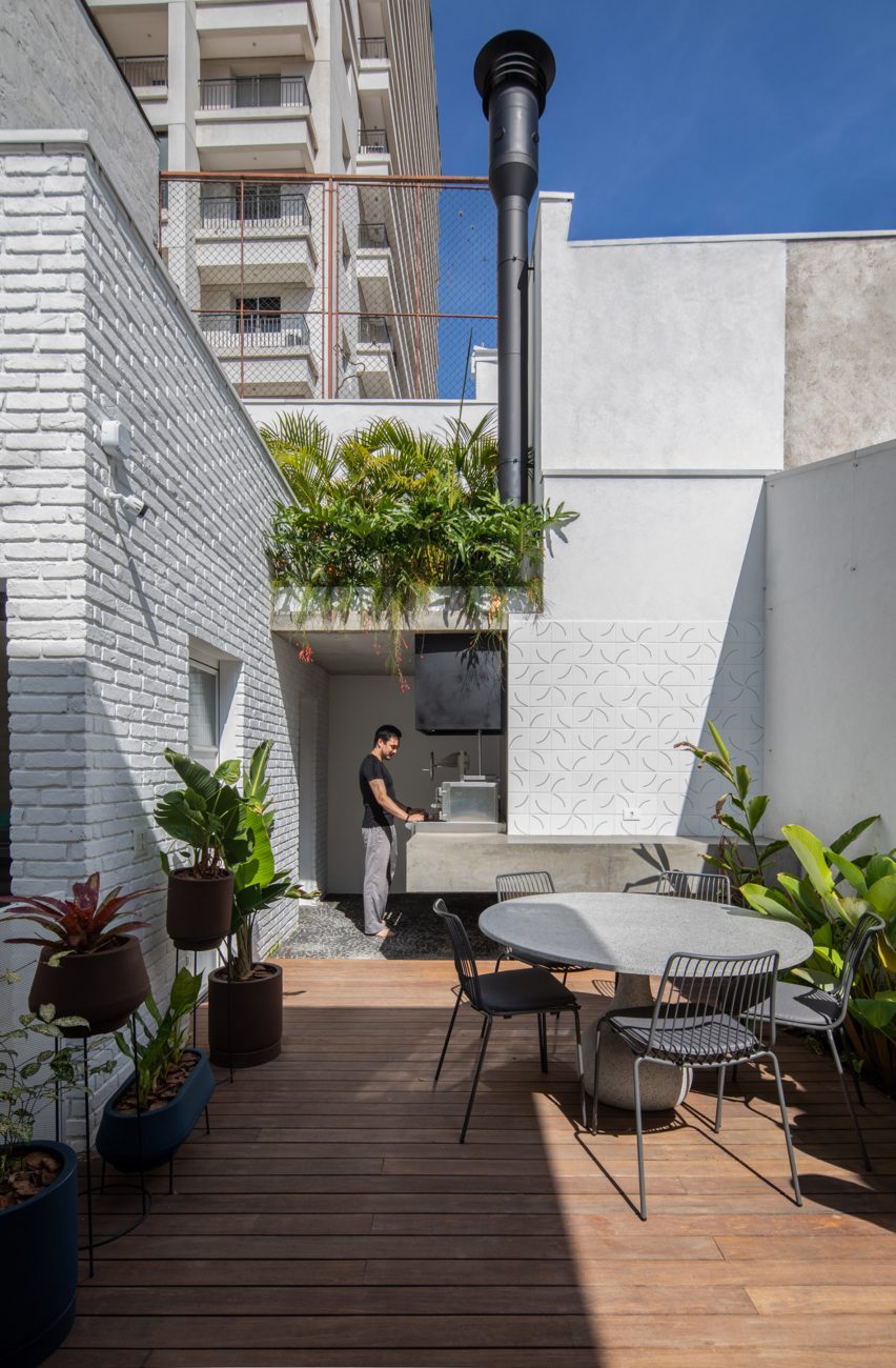 Outdoor wood decking at a white brick house in Sao Paulo