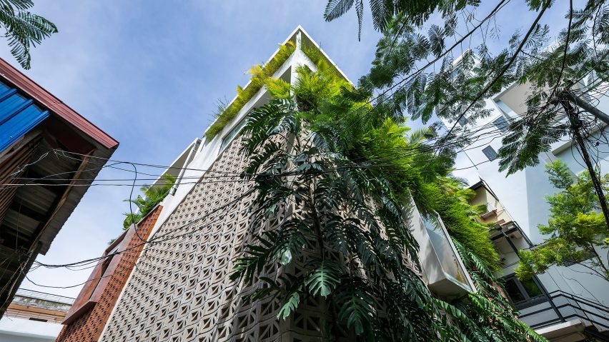 Home in Cambodia made from perforated cement blocks with overhanging plants by Bloom Architecture