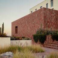 A hotel with stone facade and desert plants