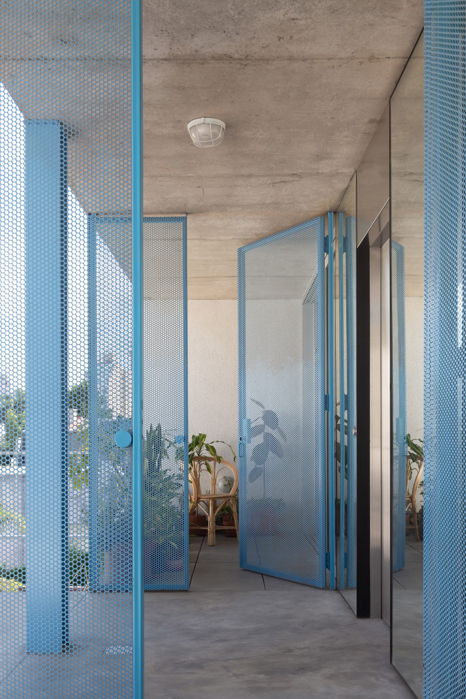 Concrete apartment building with blue mesh metal doors