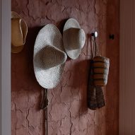 Hats on hooks on a wallpapered wall