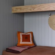 Cushioned seating nook lined with light blue-painted timber