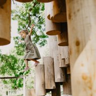 A kid navigating a wooden structure in a playground