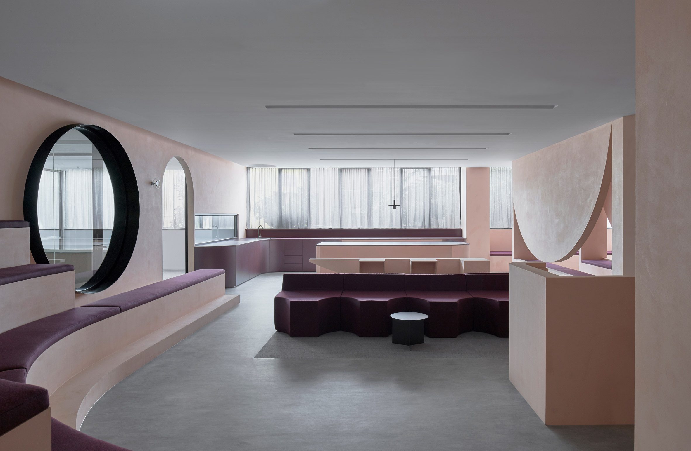 Student common area with pink plaster walls and purple seating
