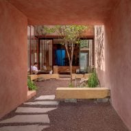 Práctica Arquitectura splits red infill home in Mexico with central courtyard