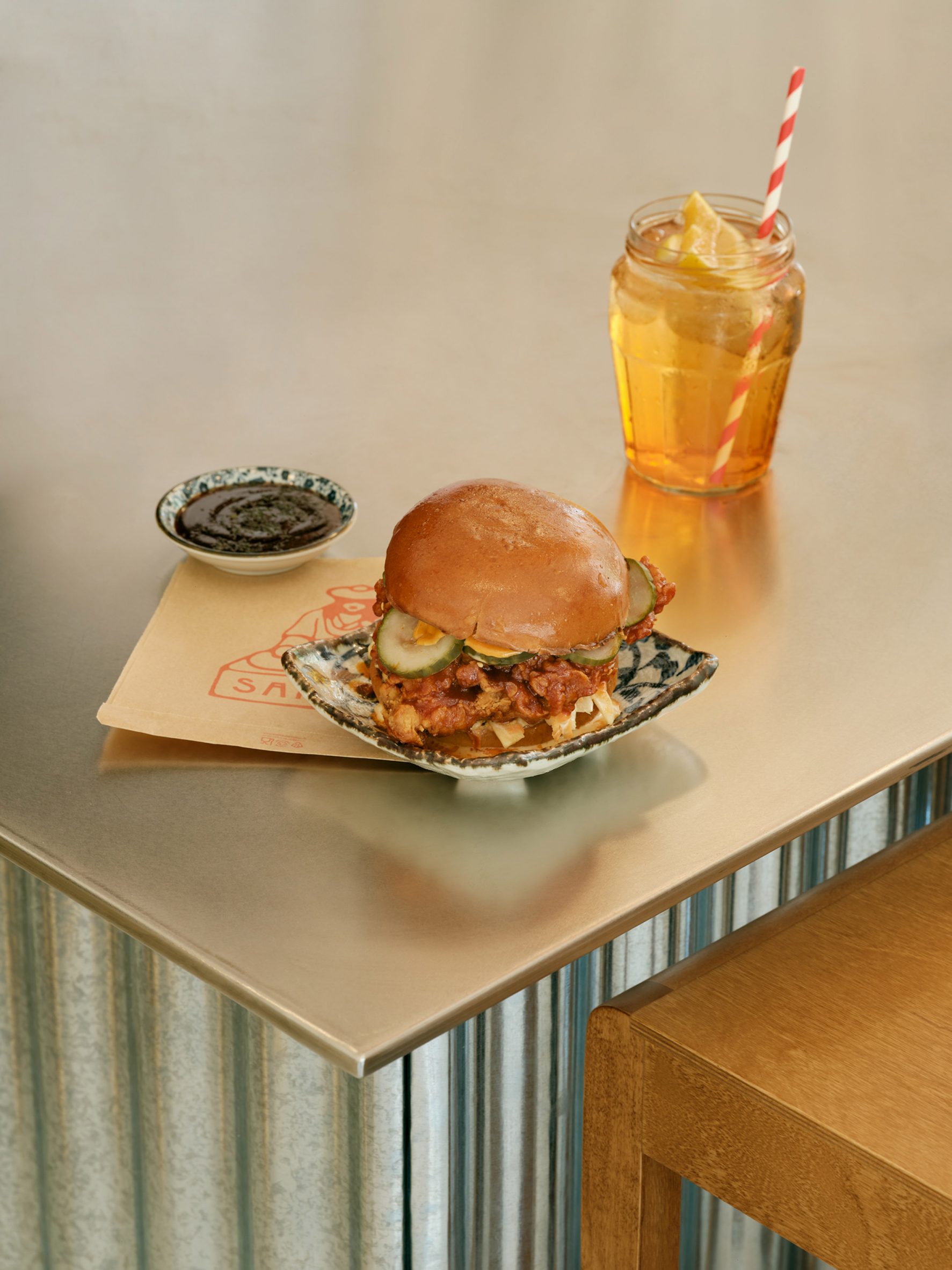 Burger and drink on stainless steel counter