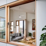 Wood-framed window looking into a living room