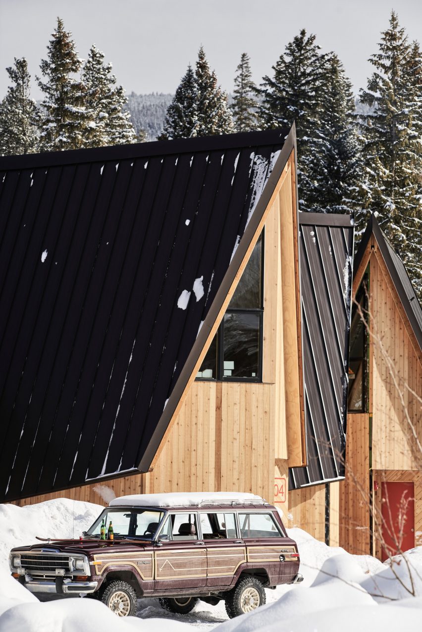 Vintage SUV parked in front of wooden A-Frame cabin
