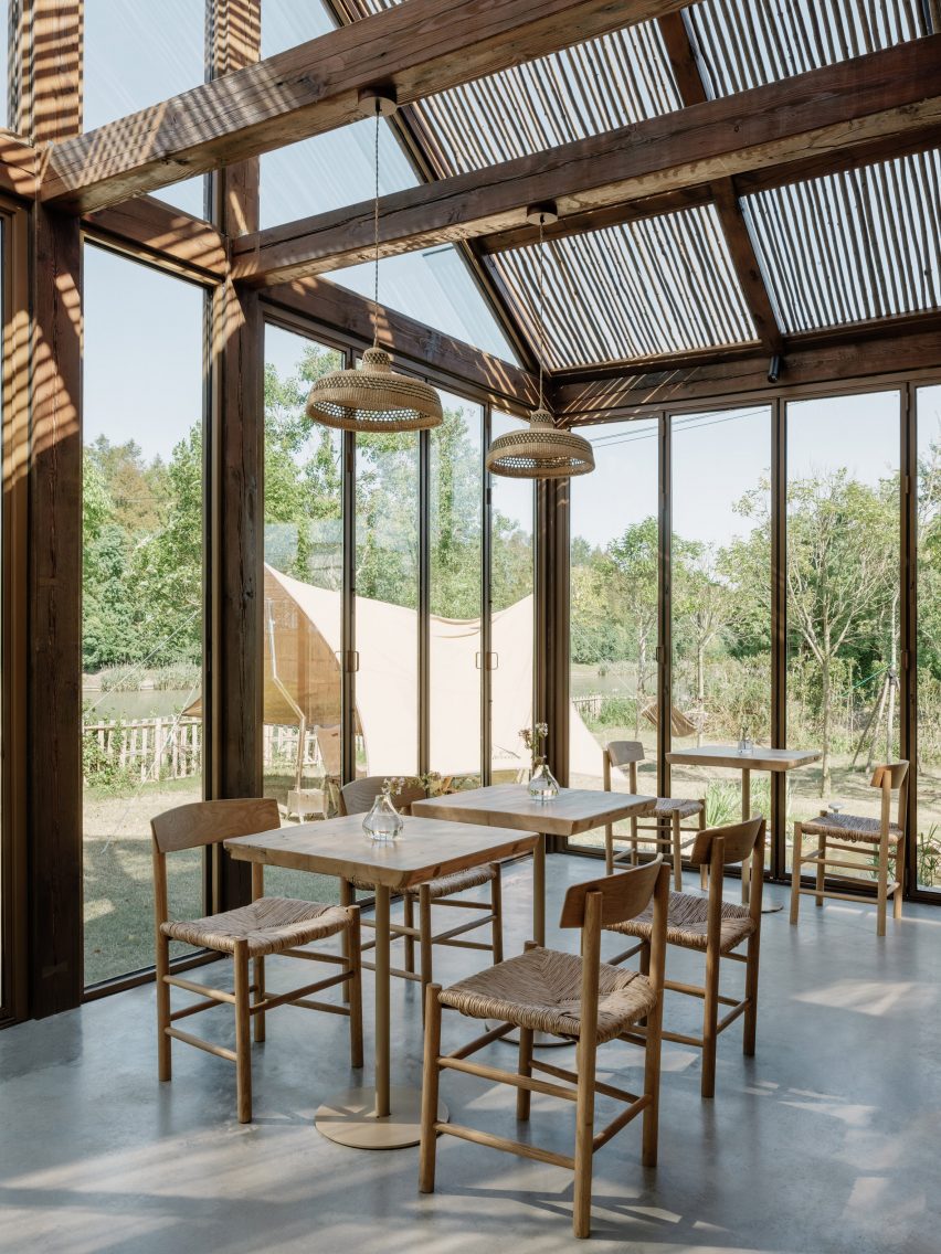 Dining area inside wood-framed glass structure