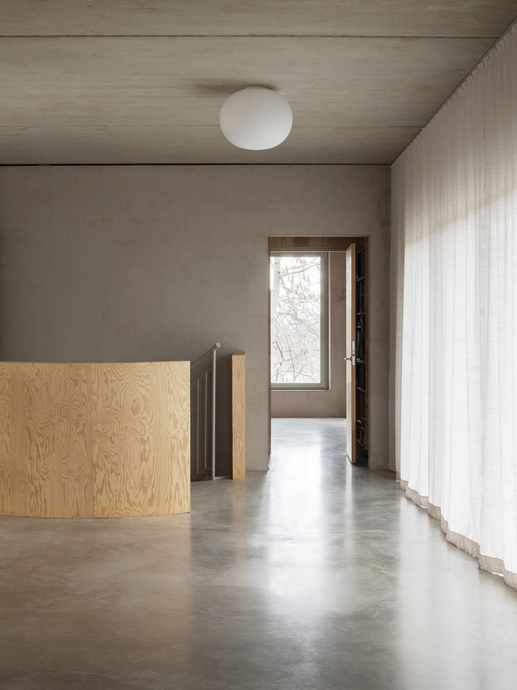 Concrete interior with plywood staircase