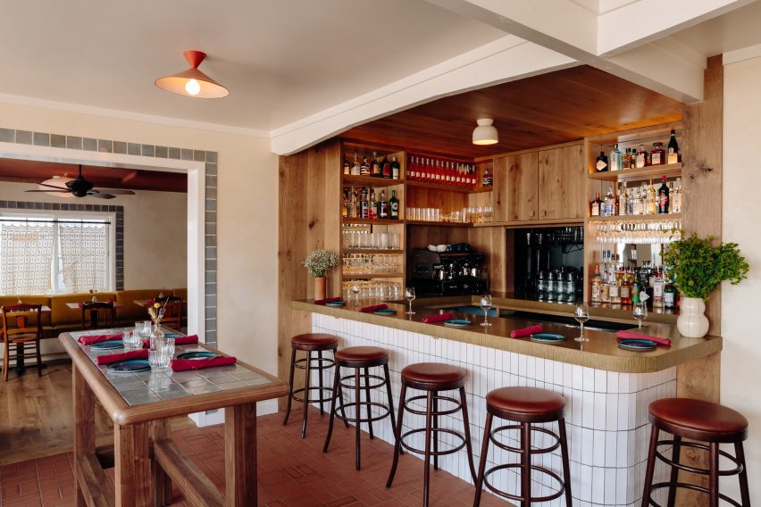 Bar area with wood cladding behind the counter and red brick flooring