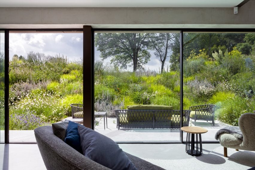 Living room interior with floor-to-ceiling glass doors leading to an outdoor patio