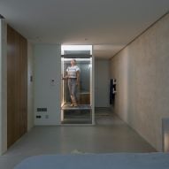 Concrete sunken room with a glass elevator