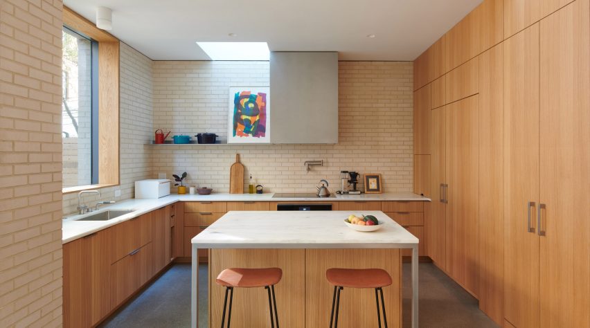 Kitchen with brick walls, oak millwork and a central island