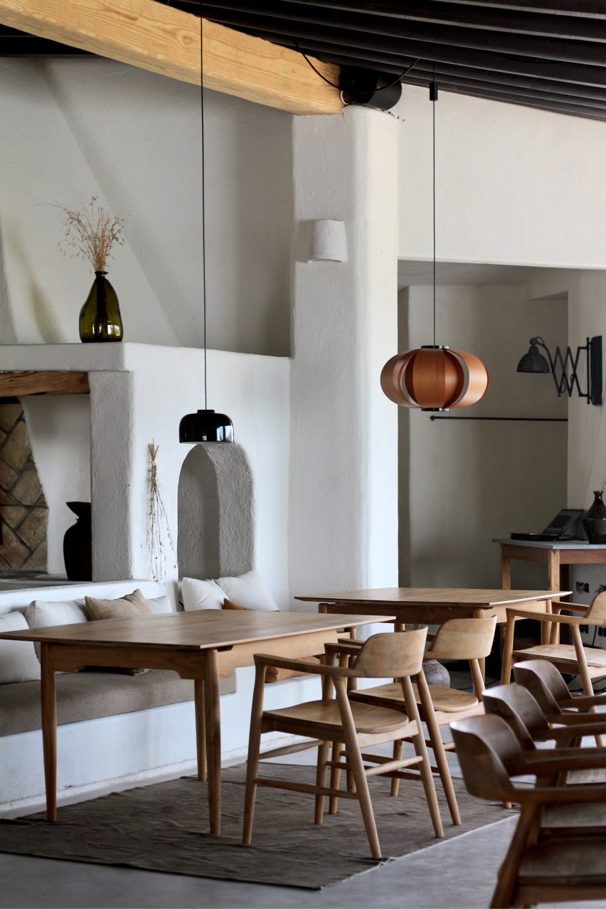 Dining area with wooden furniture and small pendant lights in Aguamadera hotel in Ibiza