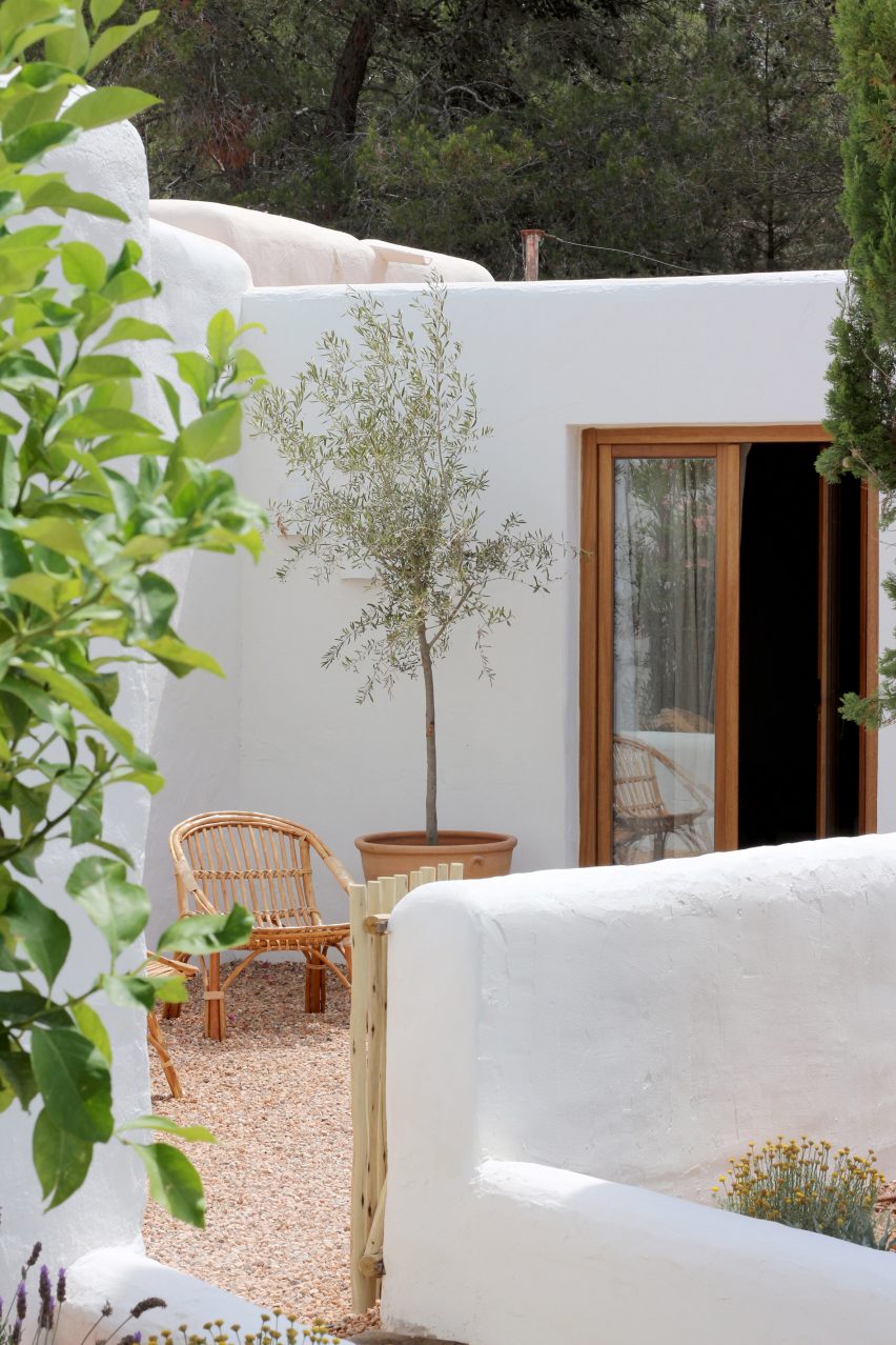 Outdoor courtyards with chairs and a potted tree in Aguamadera hotel in Ibiza