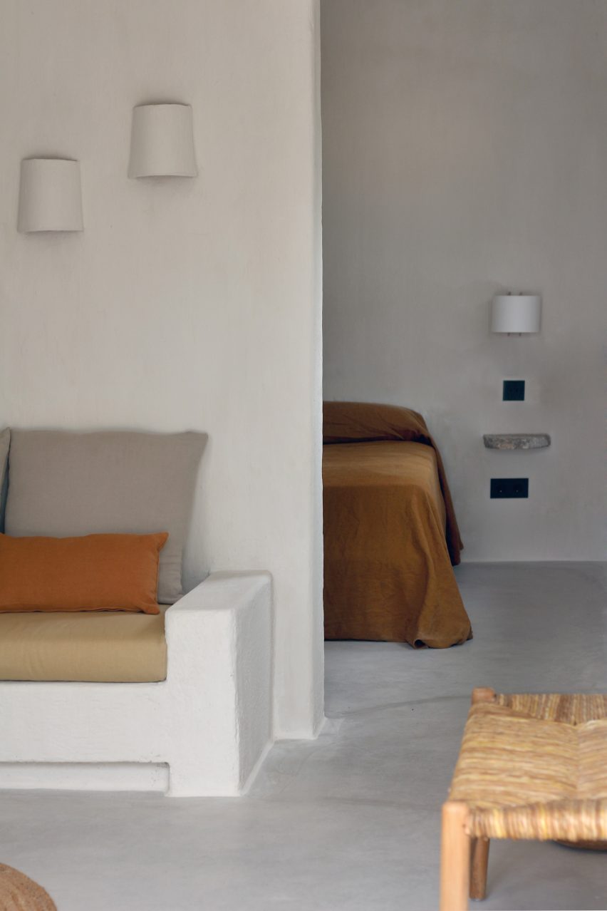Guest room with plaster walls and earth-toned upholstery in Aguamadera hotel in Ibiza