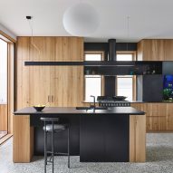 Kitchen and living area with fish tank and doors to outside in Helvetia house Fitzroy