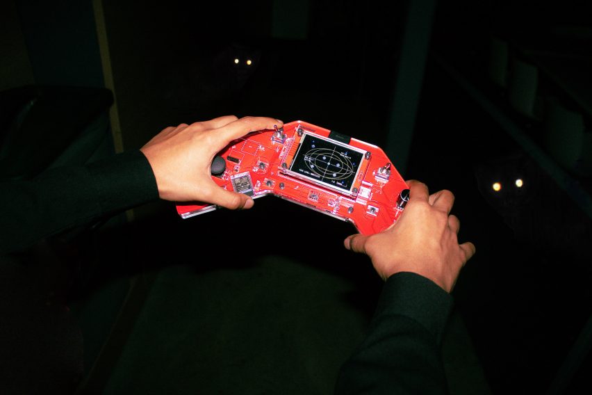 red hand held device similar to gameboy with eyes background