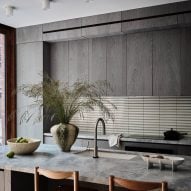 A kitchen with gray cabinetry and large kitchen island