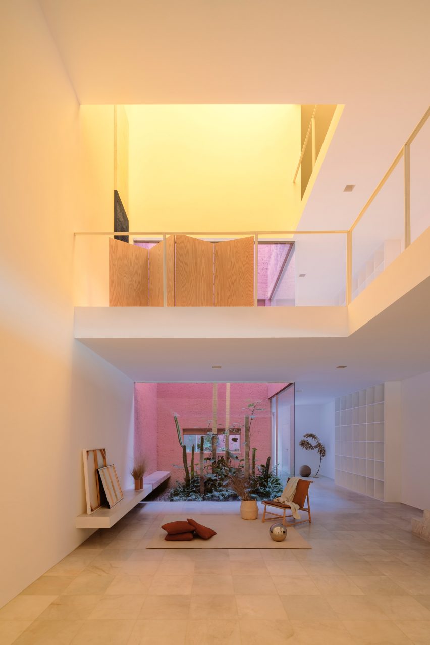 Double-height living room with yellow light pouring in from above