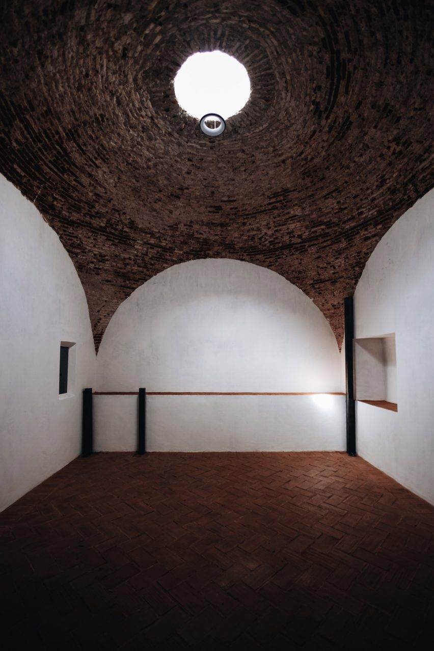 Dark room illuminated by oculus in brick ceiling