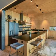 A kitchen with wooden walls and black countertop