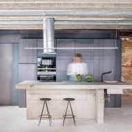 Kitchen with exposed ceiling beams and a concrete island