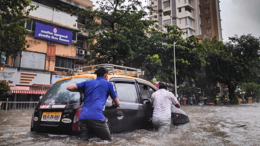Men pushing a car in a flood
