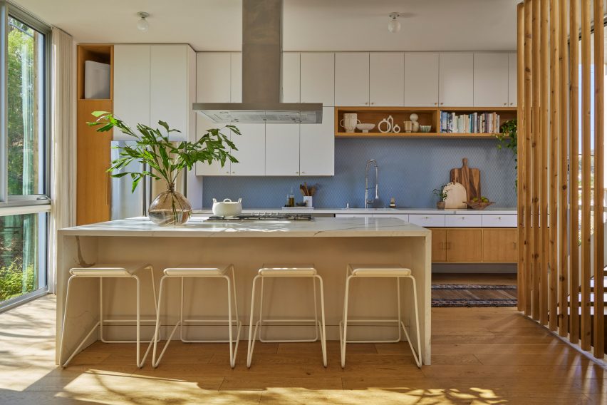A kitchen with wooden stools and white cabinets