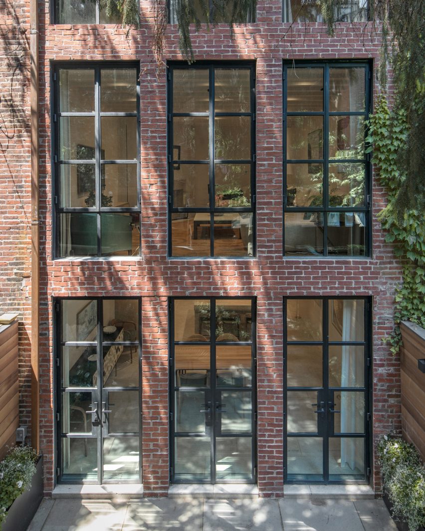 South facade of a brick building with rows of three large windows per floor