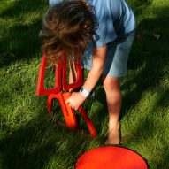A child assembling a red chair