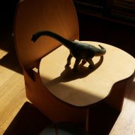 A blocky wooden chair with a dino on top