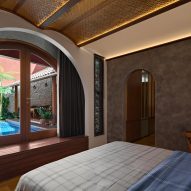 Bedroom with an arched window overlooking a swimming pool