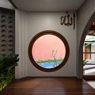 Circular window in a home looking onto a swimming pool