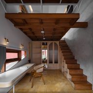 Concrete and wood interior with a mezzanine level at Distracted House