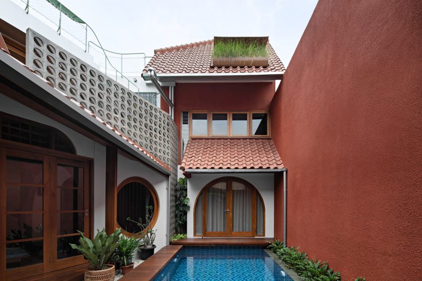 Courtyard swimming pool at a home in Jakarta with red-tiled roofs