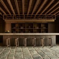 Bar with stools in a room with stone flooring and timber ceiling beams